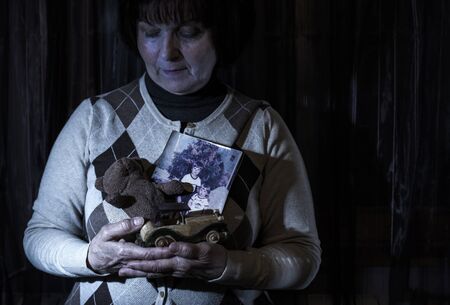 Senior woman hold pictures of childrens. Toysの写真素材