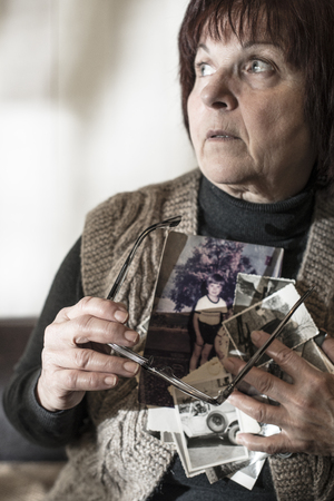 Senior woman watching old photos. Sadnessの写真素材