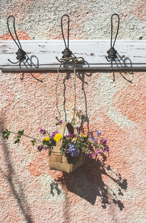 Flowers in the basket on hanger on a wall. Sunlightの写真素材