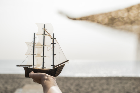 Woman with hat hold boat model on the beachの写真素材