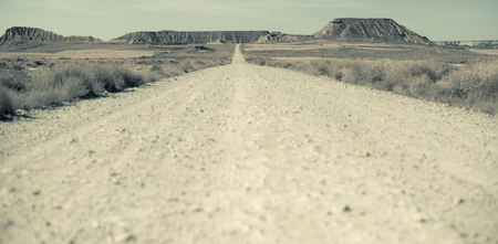 Woman walking on dirt road. Looking like a movieの写真素材