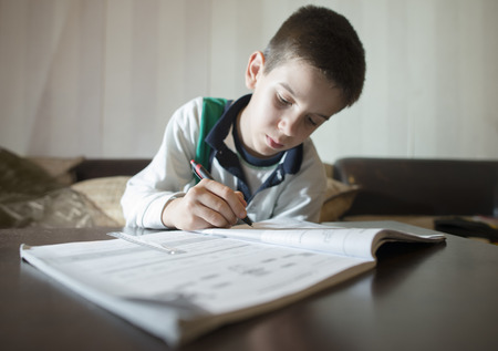 Child do his homework. Notebook for mathematic. Hand hold pen. Boy learningの写真素材