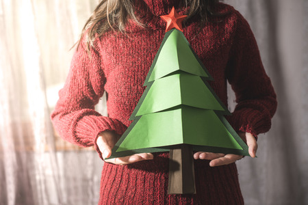 Woman in red sweater hold fir christmas tree.の写真素材
