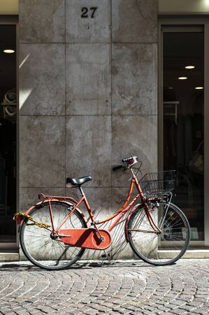 Red bike with basket on italian street. Typical italian architecture on background. Sunny day. Typical italian style.の写真素材