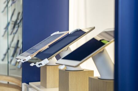 Cell Phones on shelf in telecommunication shop. Lights over GSM phones. Showcase in store for...