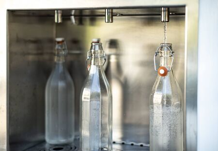 Mineral Water machine on the street. Filling mineral water bottles from a water dispenser. Pay and load drinking water.の写真素材