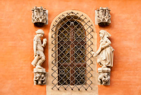 Detail on the wall of the Town Hall in Wroclaw, Poland, above the entrance to Piwnica Swidnicka: a sculpture of a drunk farmer returning back home and his furious wife, holding a clog in her hand.のeditorial素材