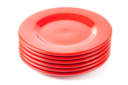Stack of colorful red ceramics plates on white background  の写真素材