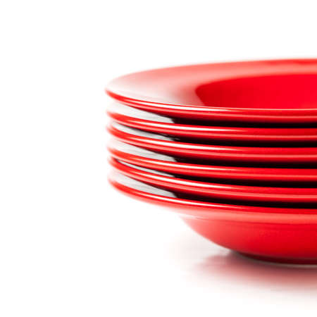 Stack of colorful red ceramics plates on white backgroundの写真素材