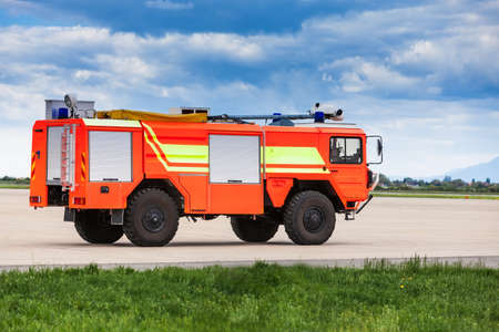 Red airport fire truck driving on the tarmac