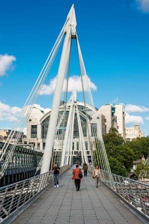 Pedestrians walking on Golden Jubilee Bridge in London  Footbridges were designed by architects Lifschutz Davidson Sandilands and completed in 2002