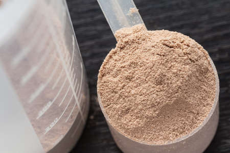 Scope of chocolate whey isolate protein next to the translucent protein shakerの写真素材