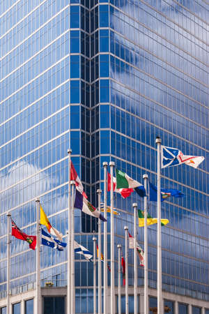 Flags of Canada and Canadian provinces against the Waterfront Centre building at 200 Burrard Street...