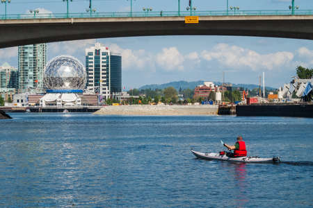Vancouver, man rowing a kayak in False Creek with Telus World of Science in the backgroundのeditorial素材