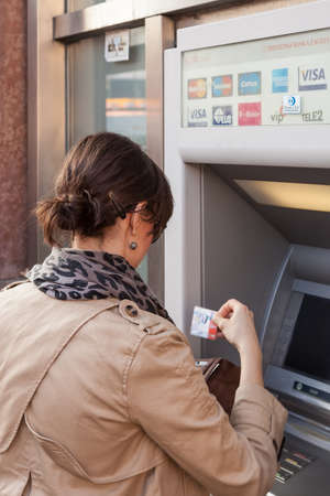 ZAGREB, CROATIA - JUNE 2, 2012: Unidentified girl withdrawing money from an ATM machine in city center. More than 4,000 ATM machines has been installed across Croatia since 1990. のeditorial素材