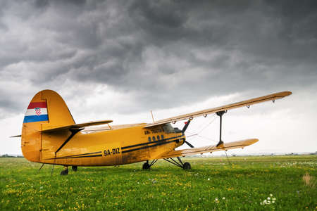 ZAGREB, CROATIA - JULY 18, 2008: Air Tractor Antonov AN-2 parked on a grass airfield Lucko under a heavily clouded sky, just before a storm broke. An-2  is Soviet mass-produced single-engine biplane utility/agricultural aircraft.のeditorial素材