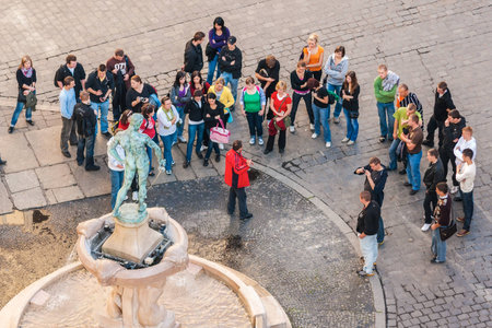 WROCLAW, POLAND - OCTOBER 7, 2009: Tourists with the tourist guide gathered in front of the Statue of The Naked Fencer in front of University of Wroclaw. Statue was designed by Hugo Lederer and erected in 1904.のeditorial素材