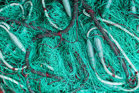 Green fishing net on the heap, closeup viewの写真素材