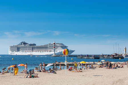 CANNES, FRANCE - AUGUST 17, 2015: Tourists at the beach in Cannes, sunbathing in front of the cruise...