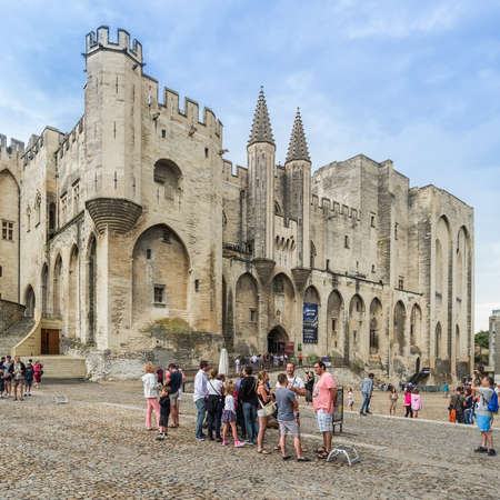 AVIGNON, FRANCE - AUGUST 13, 2015: Tourists in front of Palais des Papes (Palace of Popes), famous tourist attraction. This papal residence was seat of Western Christianity during the 14th century.のeditorial素材