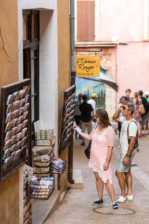 ROUSSILLON, FRANCE - AUGUST 11, 2015: Tourist walking in front of street gift shops. Roussillon It is famous for large ochre deposits found in clay surrounding village.のeditorial素材