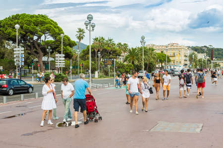 NICE, FRANCE - AUGUST 16, 2015: People walking on Promenade des Anglais street on Nice coast. Nice is 5th most populous city in France and capital of Alpes Maritimes department.のeditorial素材