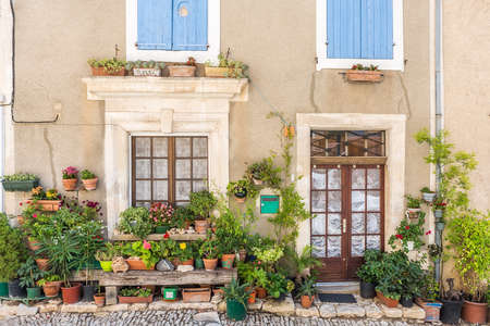 Street with greenery in flower pots on the floor and the walls in Saint-Saturnin-les-Apt, Franceの写真素材
