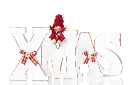 Wooden letters forming word XMAS with ribbons and red figures besides themの写真素材