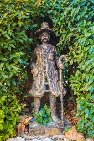 Small statue in front of the St. Etienne church in Saint-Saturnin-les-Apt, France, hidden in the hedgeの写真素材