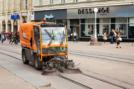 ZAGREB, CROATIA - APRIL 25, 2017: Sweeper vehicle sweeping the street of Zagreb city on the tram railway. Zagreb is largest city in Croatia and its capital.のeditorial素材