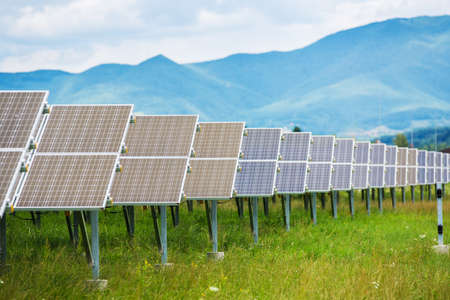 Panels of the solar energy plant under the blue sky with white clouds - clean energy concept