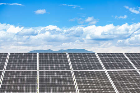 Panels of the solar energy plant under the blue sky with white clouds - clean energy concept