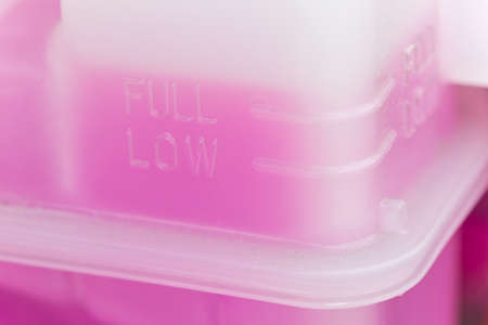 Pink cooling fluid in a plastic container - engine of a hybrid car powered both by electric battery and gasの写真素材