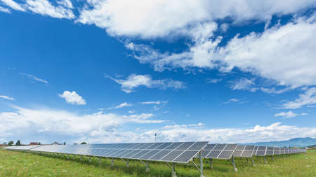 Panels of the solar energy plant under the blue sky with white clouds - clean energy conceptの写真素材
