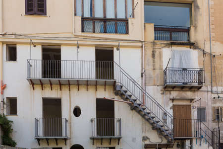 Typical building exterior in the city of Palermo, Sicily, Italy - pipes coming out of buildings and decaying exteriorの写真素材