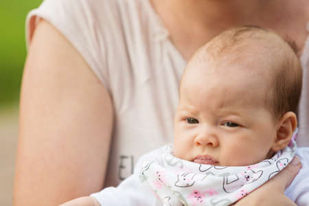 Mother holding her newborn baby daughter. concept of parenthood, happiness and family life.の写真素材