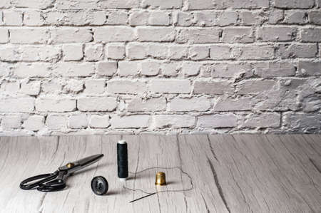 Copyspace frame with sewing tools on the wooden table with bricks backgroundの写真素材