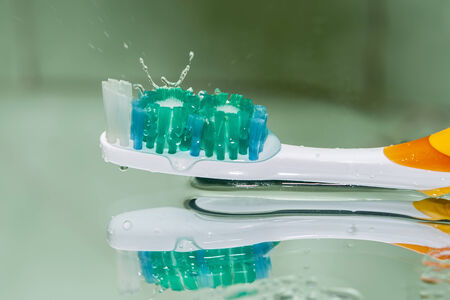 Image toothbrush with a splash of water and reflectionの写真素材