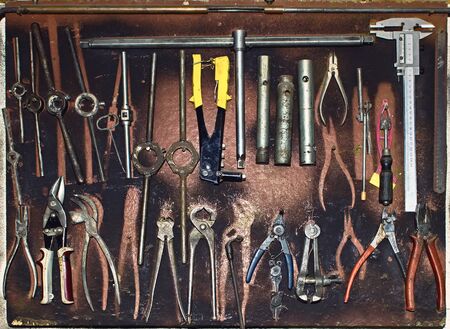 Dirty set of hand tools on a wooden panel. Vintage background with a toolsの写真素材