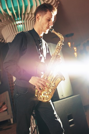 Young man plays a musical instrument saxophone. Saxophone instrument for jazz.の写真素材