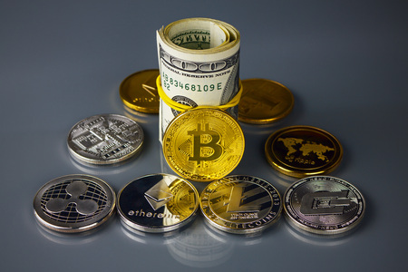 Coins of different crypto-currencies with dollars. Bitcoin, dash, ripple, ethereum litecoin