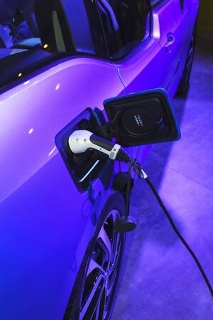 EV Car or Electric car at charging station with the power cable supply plugged. Eco-friendly...