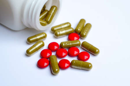 Herbal medicine pills spilling from bottleの写真素材