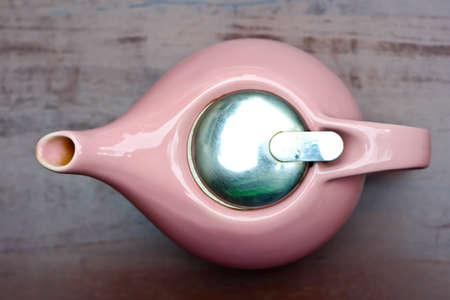 Pink ceramic pot on a wooden table brown.の写真素材