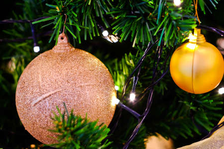 Closeup bauble hanging from a decorated Christmas treeの写真素材