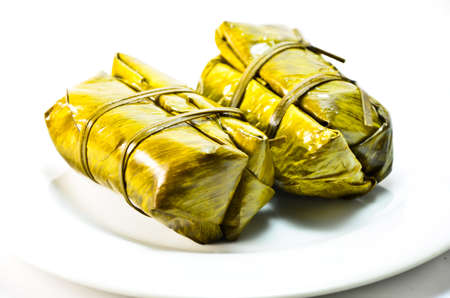 Porridge tie. Sticky rice wrapped in banana leaves, banana filling, steamed cooked food.の写真素材
