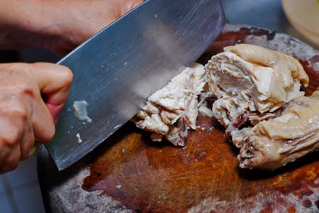 Cutting of chicken meat on a finishing kitchen boardの写真素材