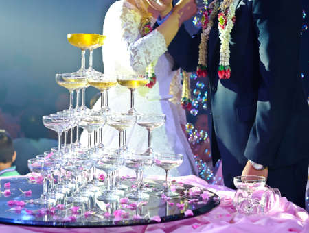 Hands of bride and groom with glasses of champagneの写真素材