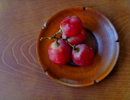 Red grapes on a wooden table (grape)の写真素材