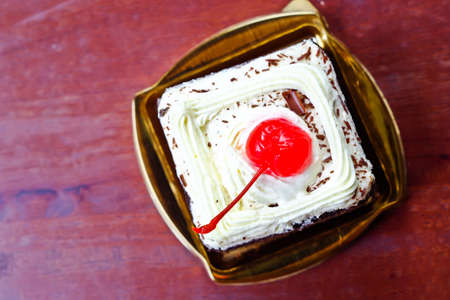Chocolate cake with cherry on wood tableの写真素材